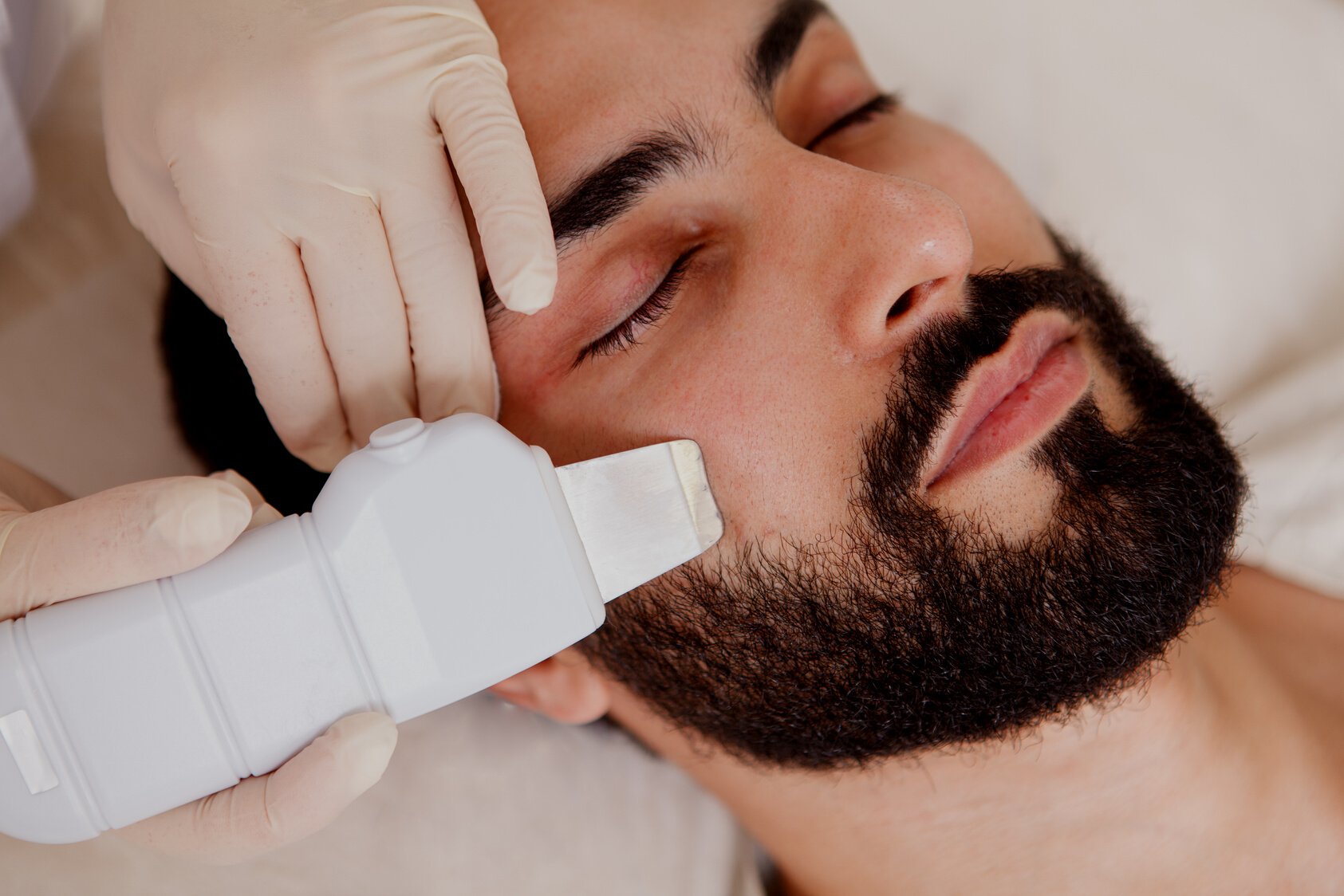 Male client getting facial treatment at beauty clinic