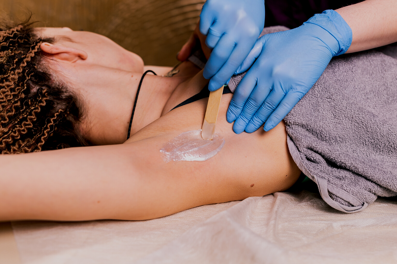 Waxing Woman Armpit. Salon Wax Beautician Epilation Procedure. Waxing Female Body for Hair Removal by Therapist Close up. Smooth Underarm Concept.